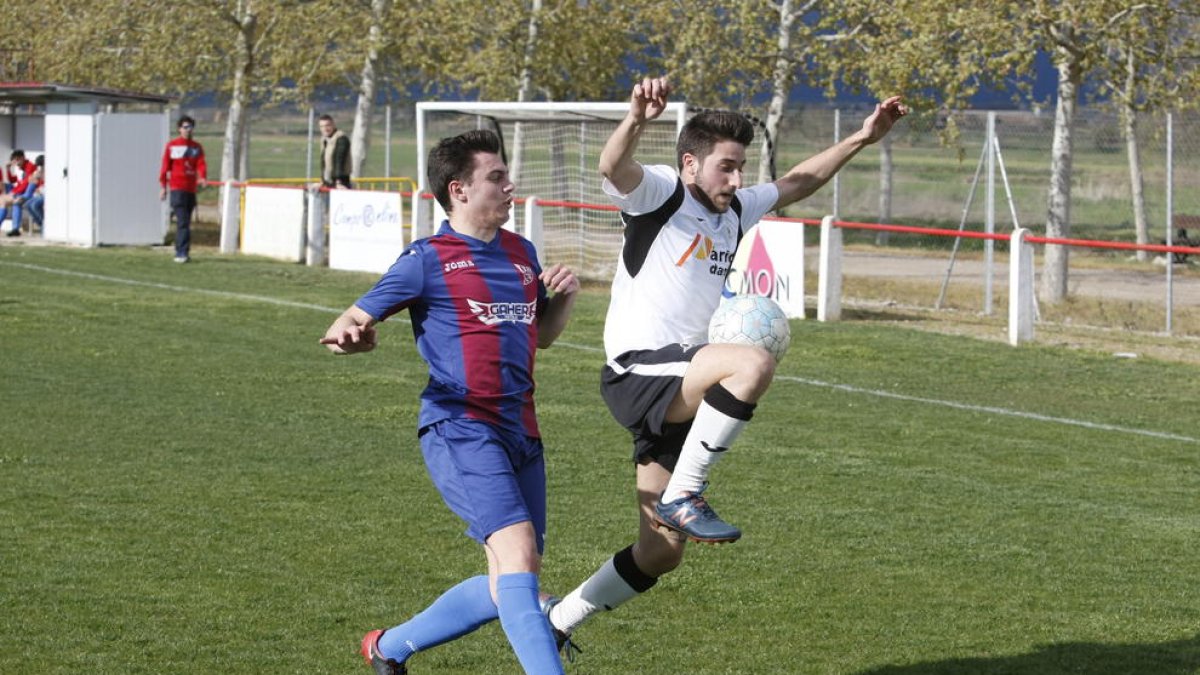 Un jugador del Vallfogona controla el balón ante la presión de otro jugador de L’Albi.