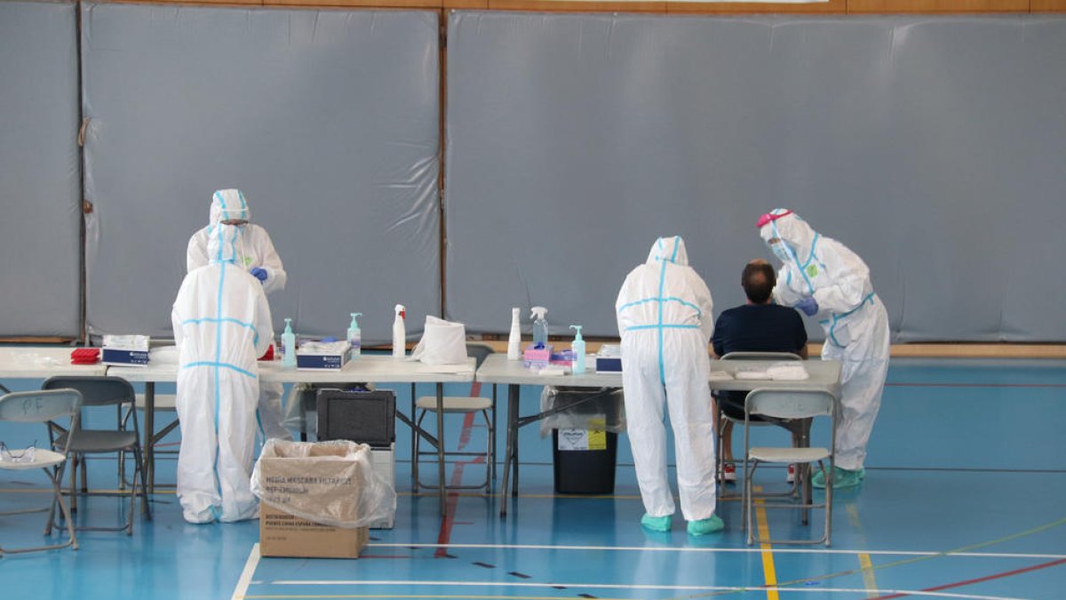 Sanitarios someten a un test PCR a un vecino de Girona, ayer.