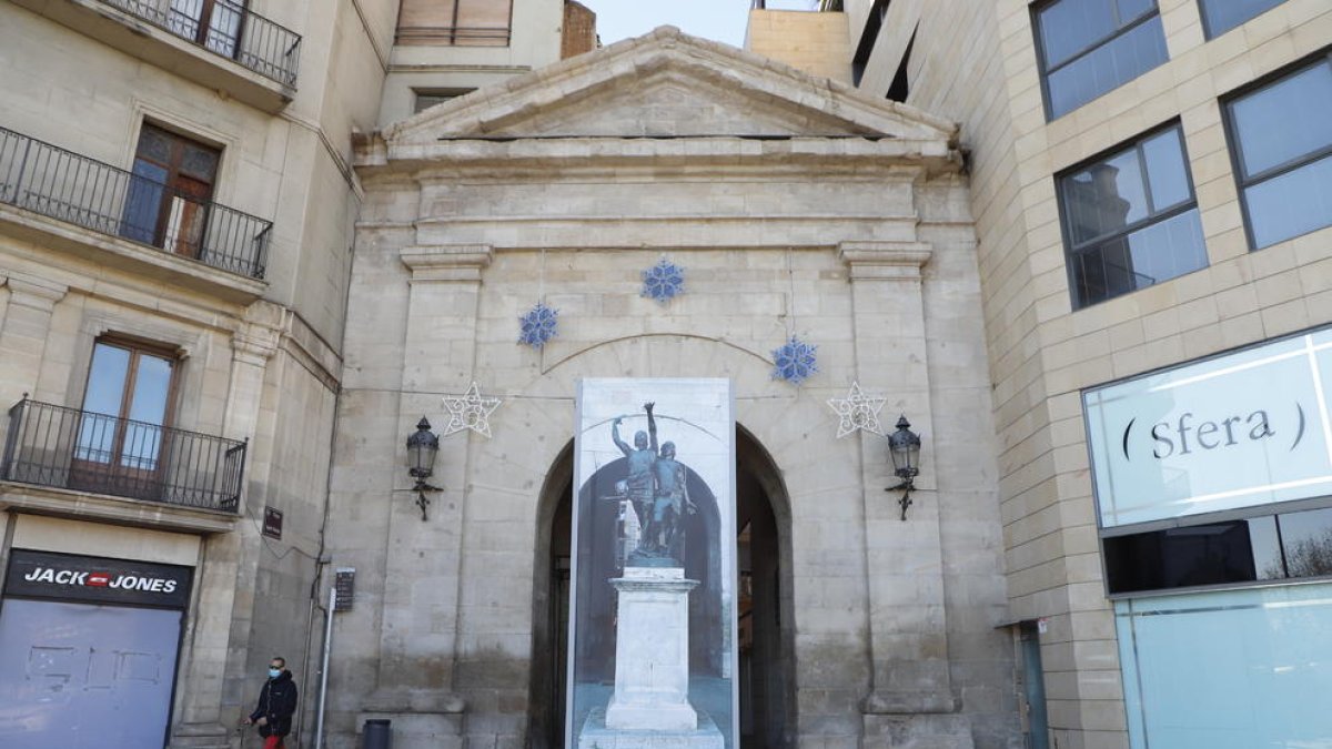 La protecció amb la imatge de l’estàtua al voltant del pedestal.