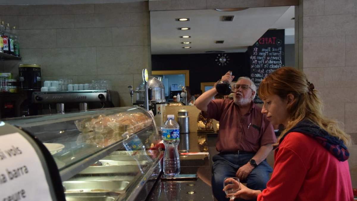 La barra de un bar con el espacio delimitado con cinta adhesiva en La Seu d’Urgell (izquierda) y un establecimiento con la barra también abierta en Sort.