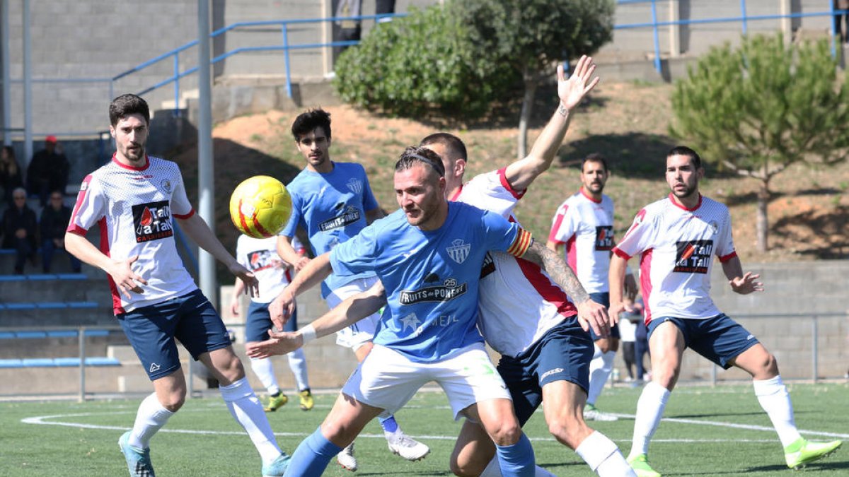 Un jugador del Alcarràs protege el balón ante la presión de un defensor del Sant Ildefons.