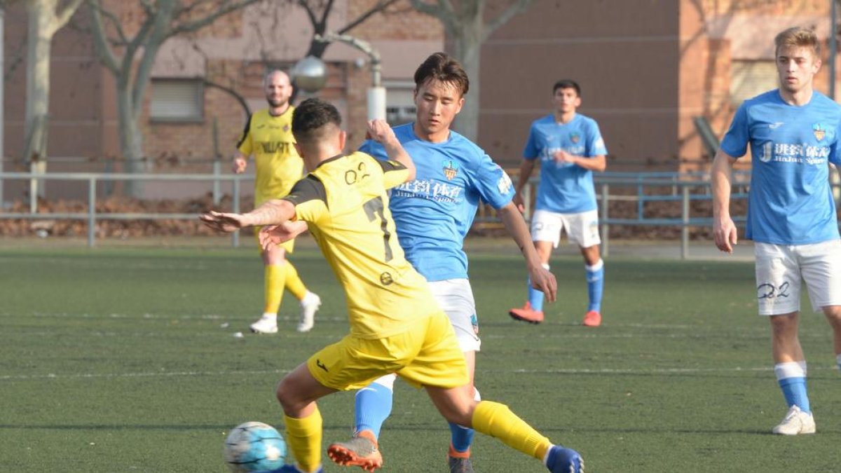 Liu, del Lleida B, y Pablo Bernal, del Balaguer, pugnan por el balón.