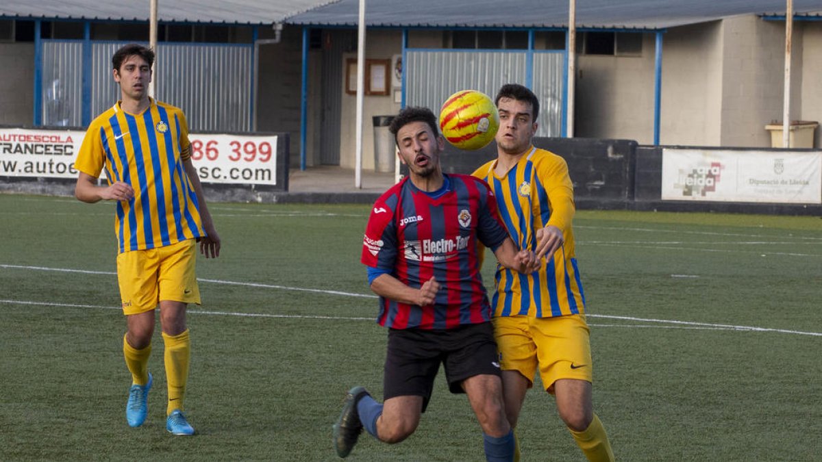 Un jugador del Tàrrega pugna por un balón dividido con un futbolista del Atlètic Sant Just.