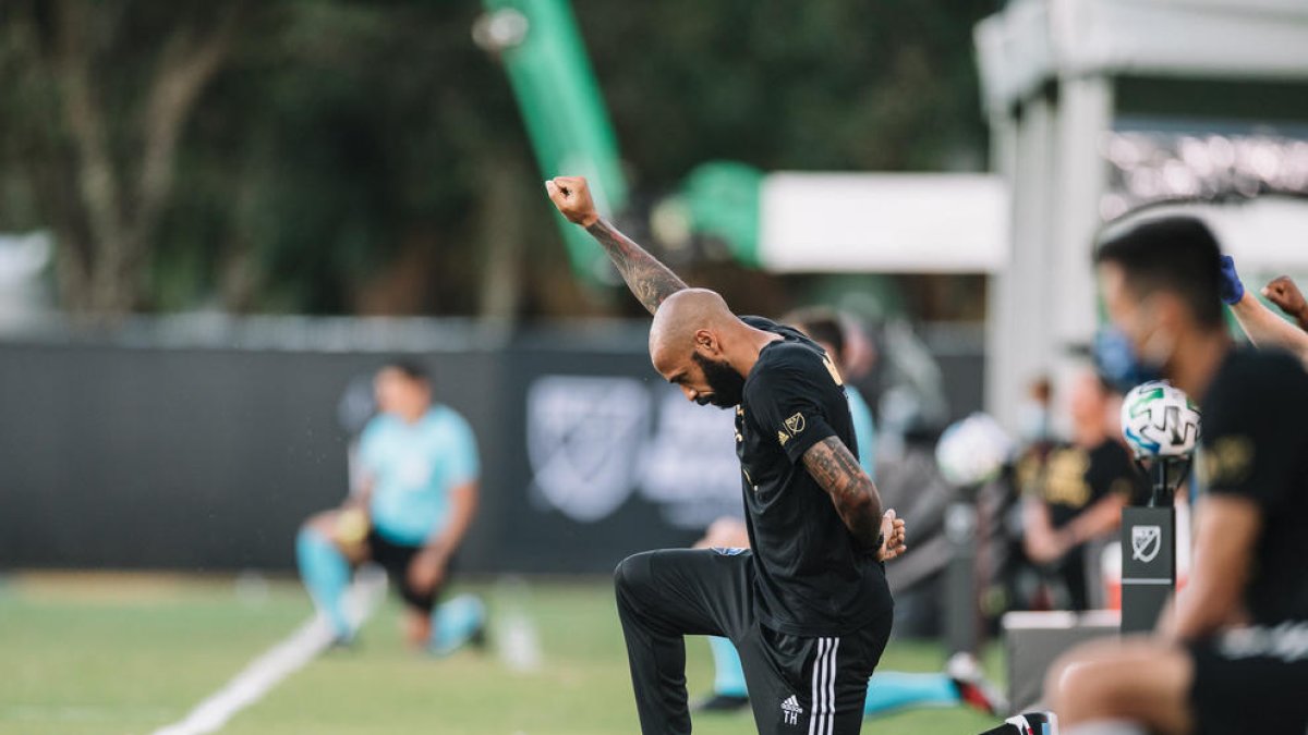 Henry, agenollat en un gest contra el racisme.