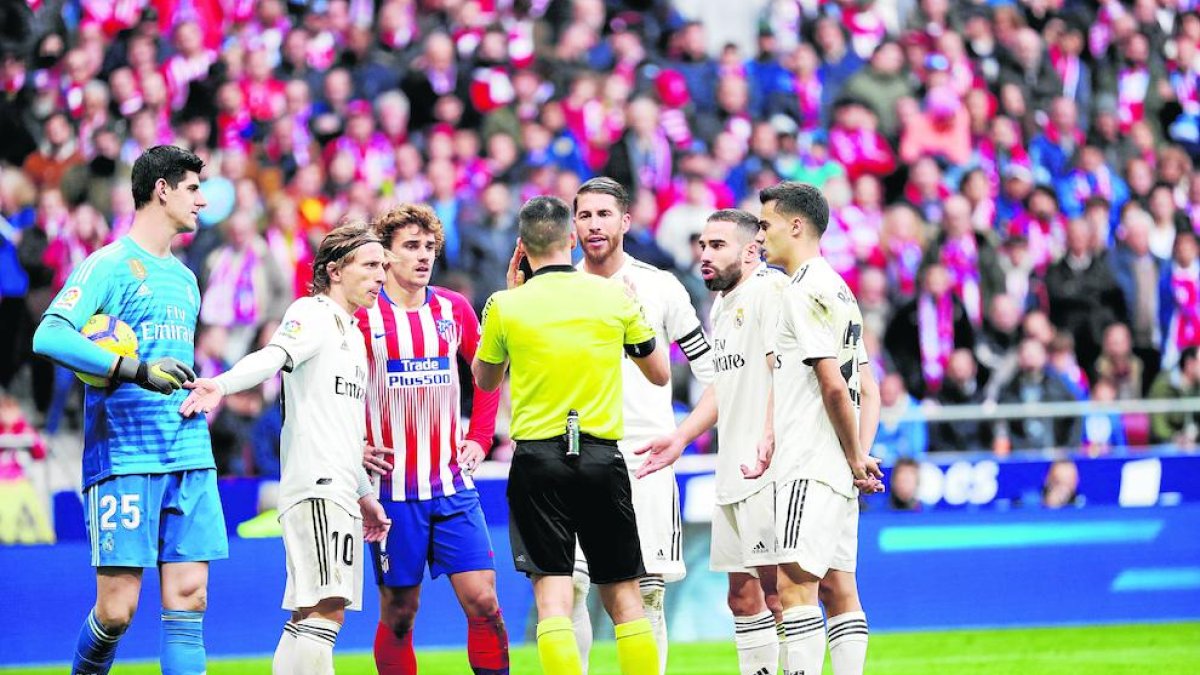 Jugadors del Reial Madrid i de l’Atlètic conversen amb el lleidatà Estrada Fernández, ahir.