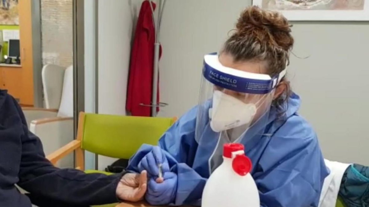 Una sanitària fent una prova en una residència.