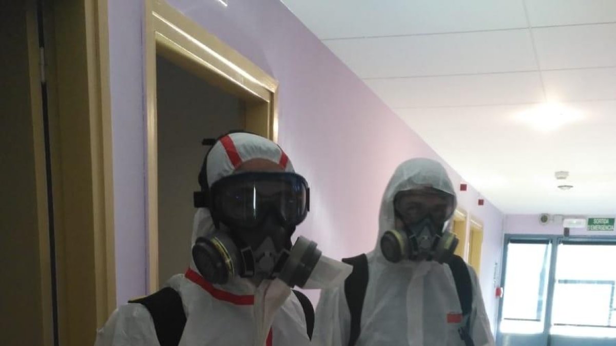 Dos trabajadores desinfectando uno de los centros de La Pobla.