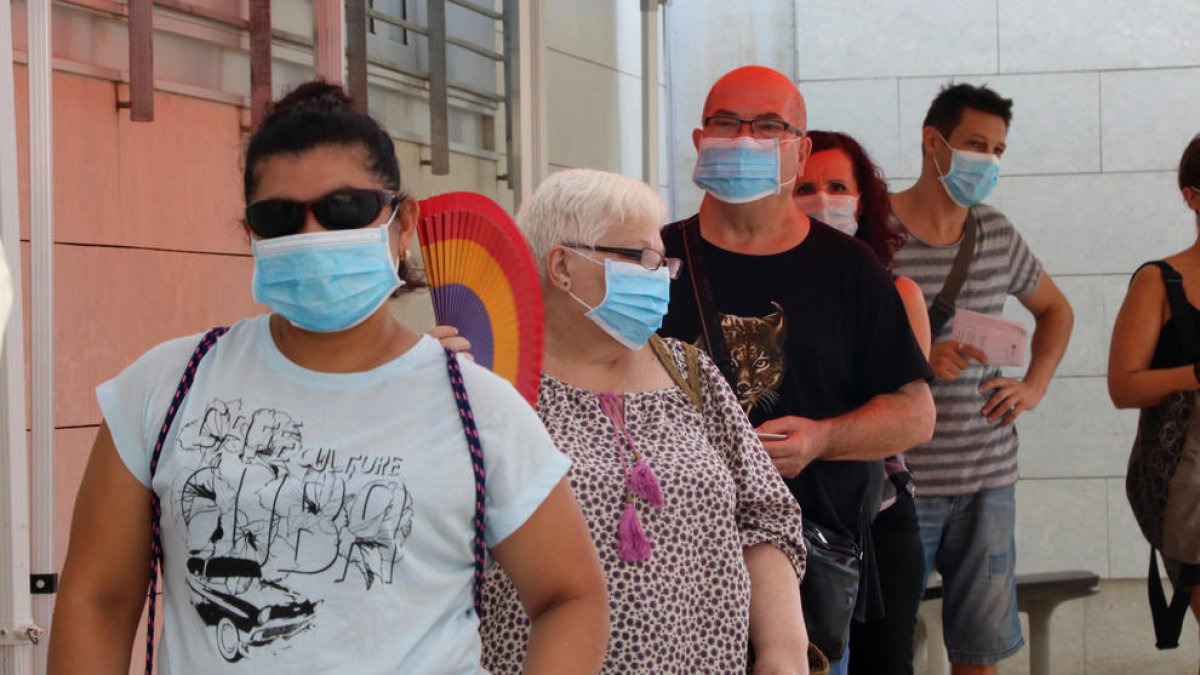 Vecinos de Santa Coloma de Gramenet, ayer, esperando para someterse a una prueba PCR.