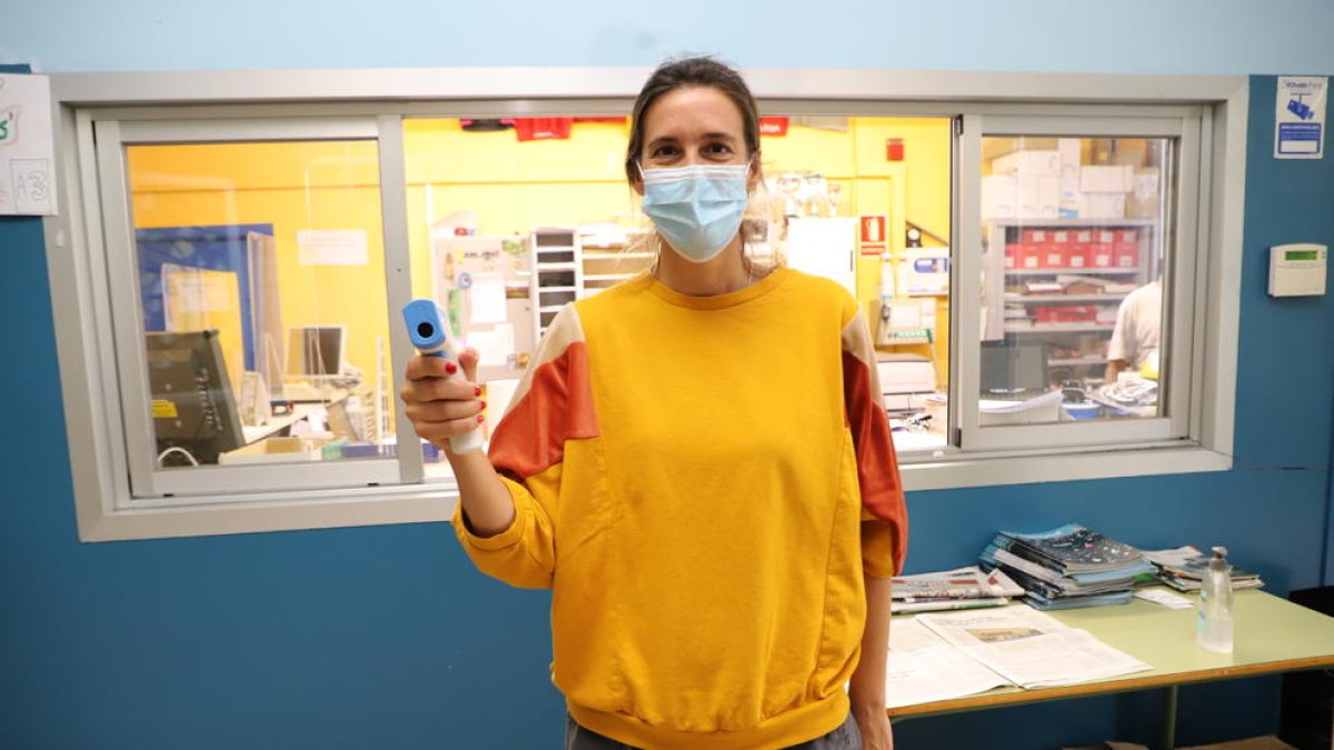 Una professora del Joan Oró, amb un termòmetre.