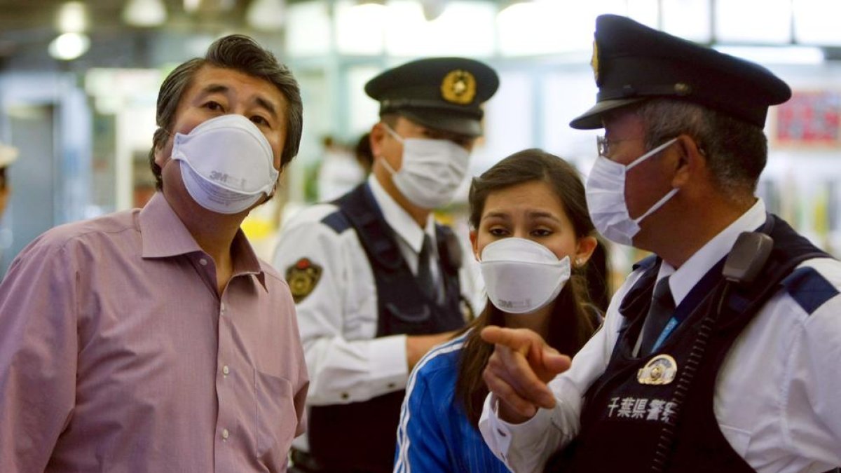 Ciudadanos y policías japoneses usan mascarillas para evitar contagiarse.