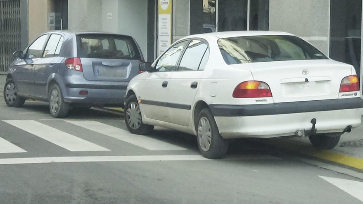 Algunos coches invadiendo un paso de peatones.