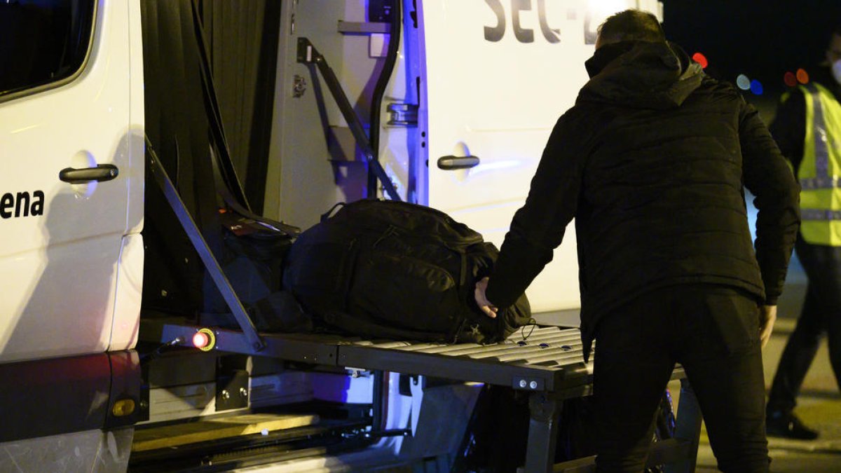 Un dels espanyols repatriats de la ciutat xinesa de Wuhan pel risc de coronavirus carrega maletes en un autobús abans de ser traslladat a l'hospital per la quarantena el 31 de gener.