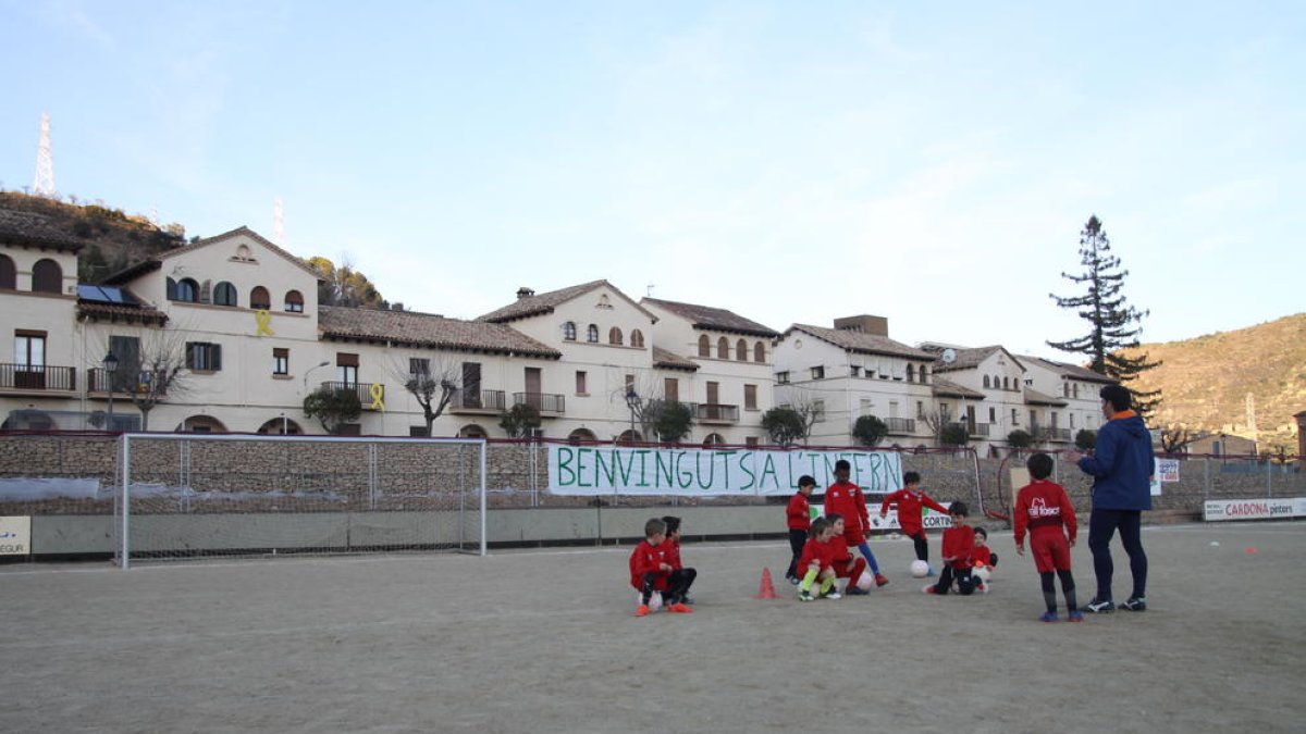 Un grupo de niños junto a su entrenador ayer en el campo de tierra del Pobla durante el entrenamiento.
