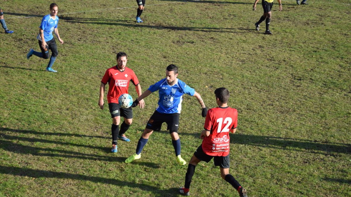 Un jugador del Sant Guim trata de controlar el esférico ante la presión de varios rivales.