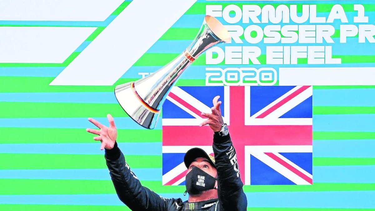 Hamilton celebra la victòria número 91 llançant el trofeu a l’aire.