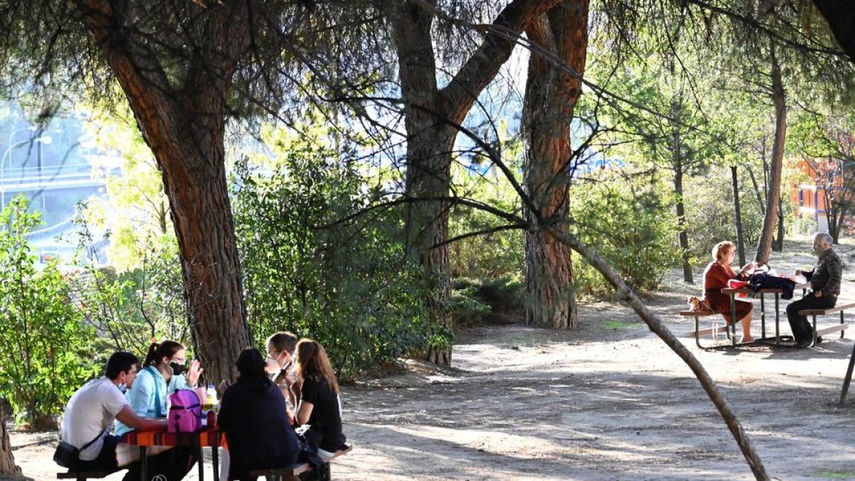 Vecinos del madrileño barrio de Moratalaz ayer en un parque, respetando las medidas de seguridad.