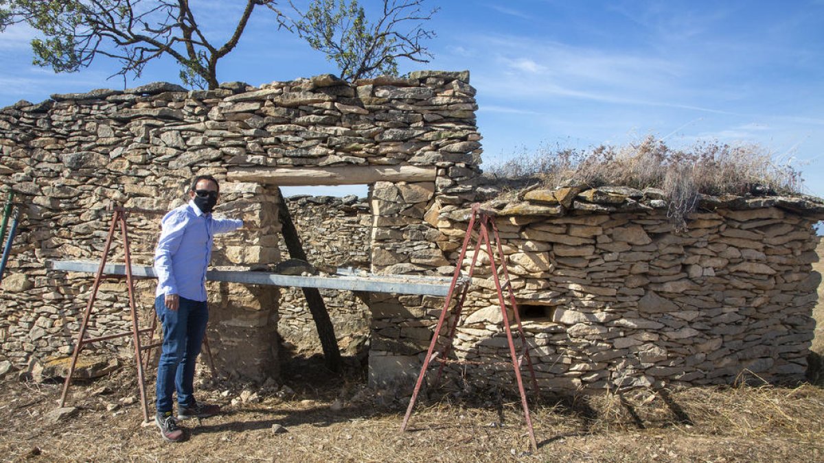 El alcalde, Jaume Pané, junto a una de las cabañas que restauran.