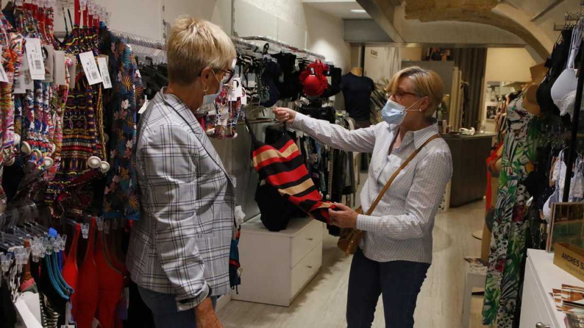 La dependienta de una tienda del Eix Comercial atiende a una clienta.