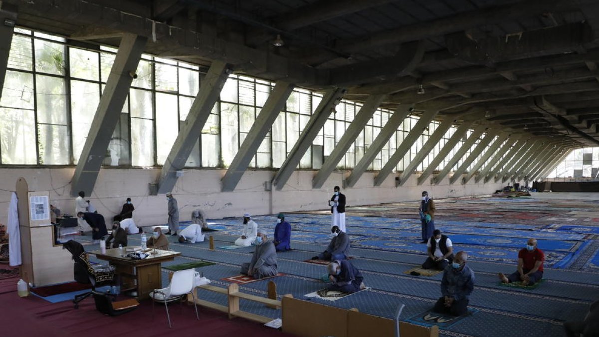 Els fidels que van anar ahir a resar al Palau de Vidre ho van fer amb mascareta i guardant distàncies.