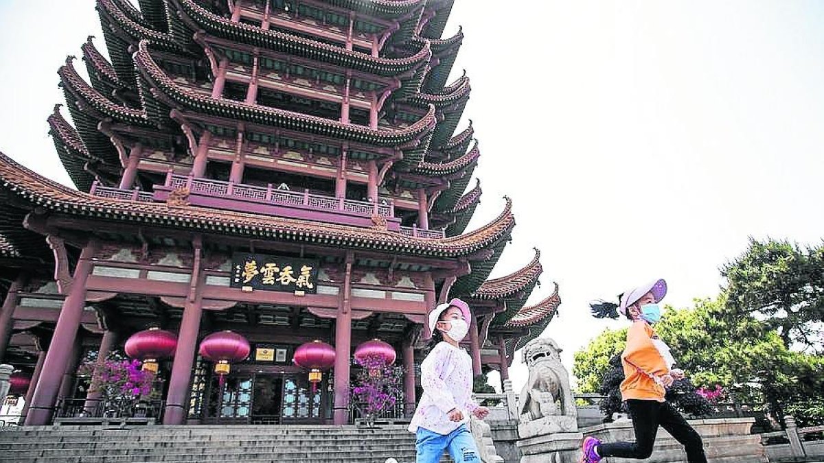 Dos niñas en Wuhan, donde se anuncian 11 millones de pruebas.