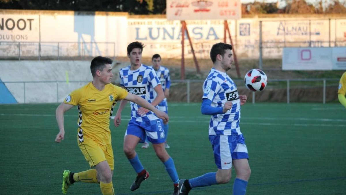 Un jugador del Tamarit controla la pilota amb el pit en una acció del duel.