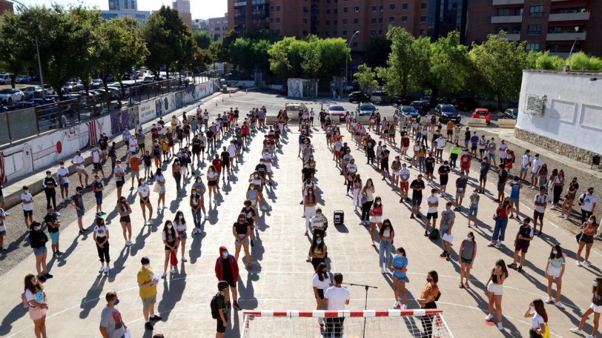 Los alumnos de un instituto de Tarragona, durante la presentación del curso escolar en el patio, con mascarilla y guardando las distancias.