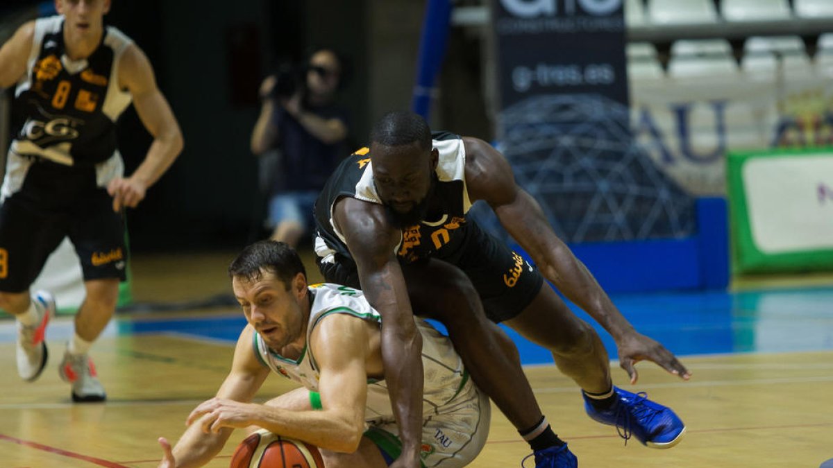 El jugador del ICG Força Lleida Mike Carey lucha por el balón junto al local Chema García en una acción del partido de ayer.