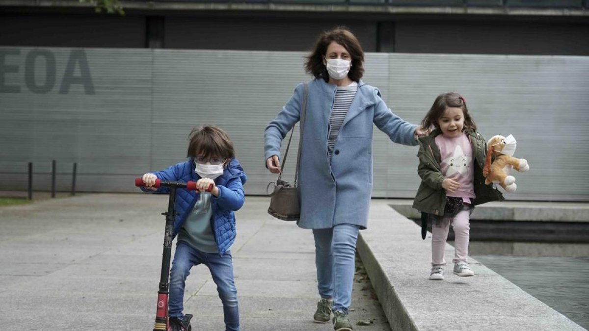 Una dona passeja amb dos nens pels carrers de Bilbao.