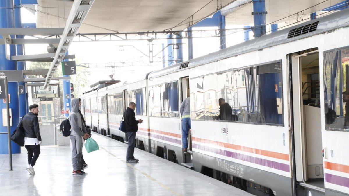 Uns quants viatgers, alguns amb mascareta, ahir davant d’un dels primers trens de la línia de la costa (esquerra) i l’interior d’un vagó amb una sola persona.