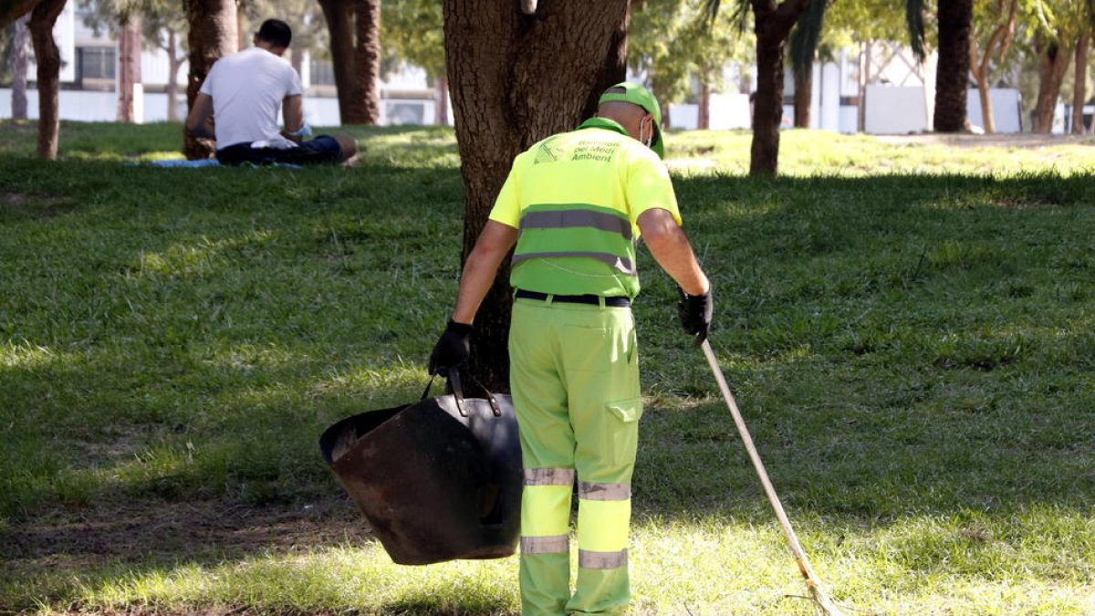 Imatge d’un membre del servei de neteja escombrant el parc de la Barceloneta.