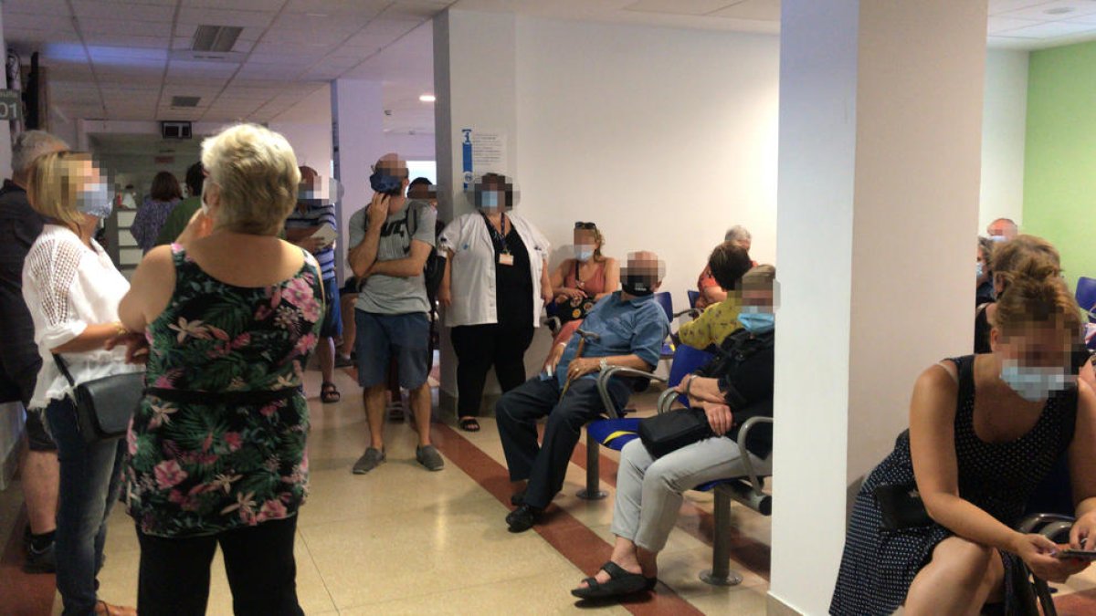 Algunos pacientes de pie ayer en una de las salas de espera.