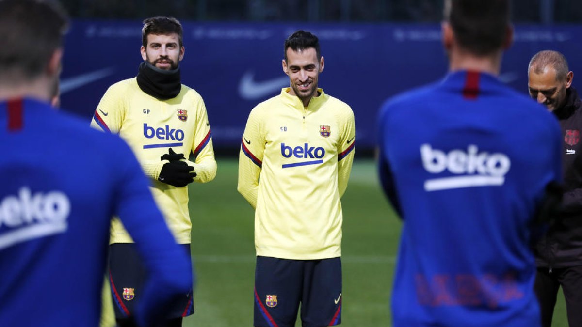 Piqué y Sergio Busquets, en un momento de la sesión de entrenamiento de ayer.