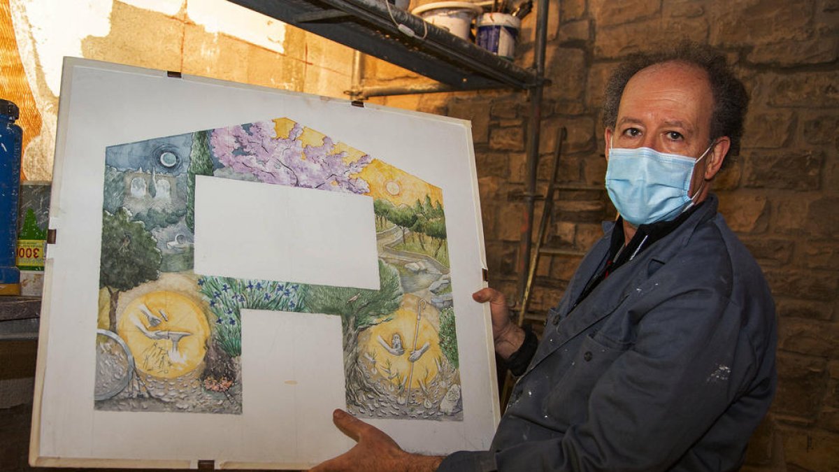 Minguell mostrando el diseño completo que lucirá una pared de la ermita cuando esté terminado.