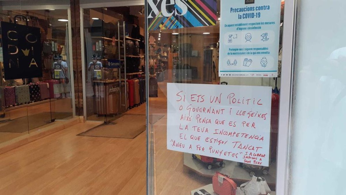 Cartells amb missatges en comerços tancats a l'Eix Comercial de Lleida