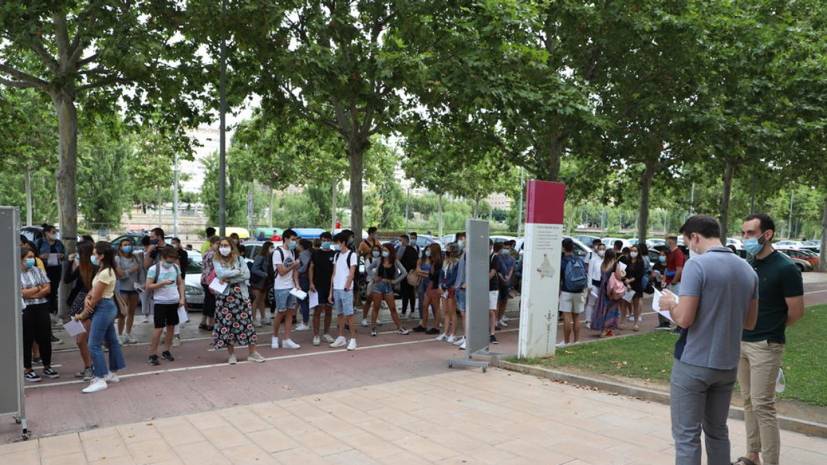 Un grupo de alumnos escucha las indicaciones de los profesores antes de entrar en el aula a hacer las pruebas de aptitud personal (PAP).