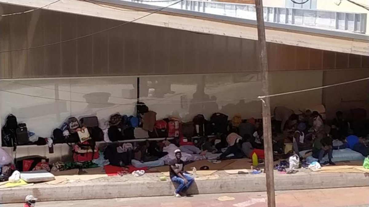 Imagen de un grupo de personas en la calle junto a la Casa de Fusta.