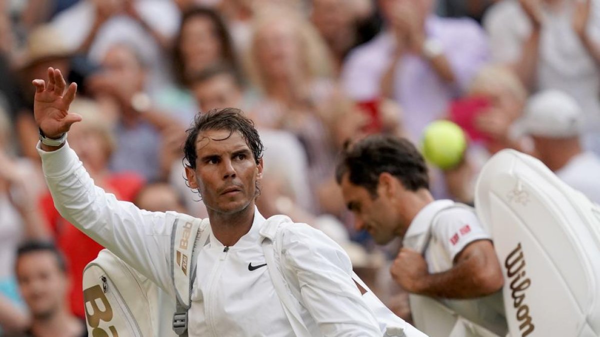 Rafa Nadal se despide de los aficionados, con Federer a su lado, tras caer ante el suizo.
