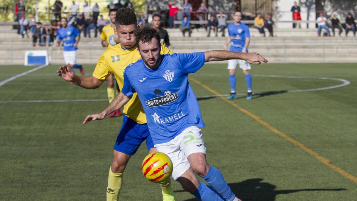 Un jugador del Alcarràs protege el balón ante la presión de un jugador de El Catllar.