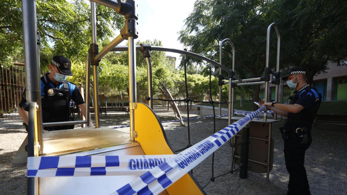 Agentes de la Urbana precintando parques infantiles en Lleida.