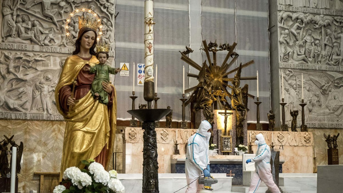 Operaris desinfecten l’església de Sant Joan Bosco de Roma, que podrà reobrir demà.