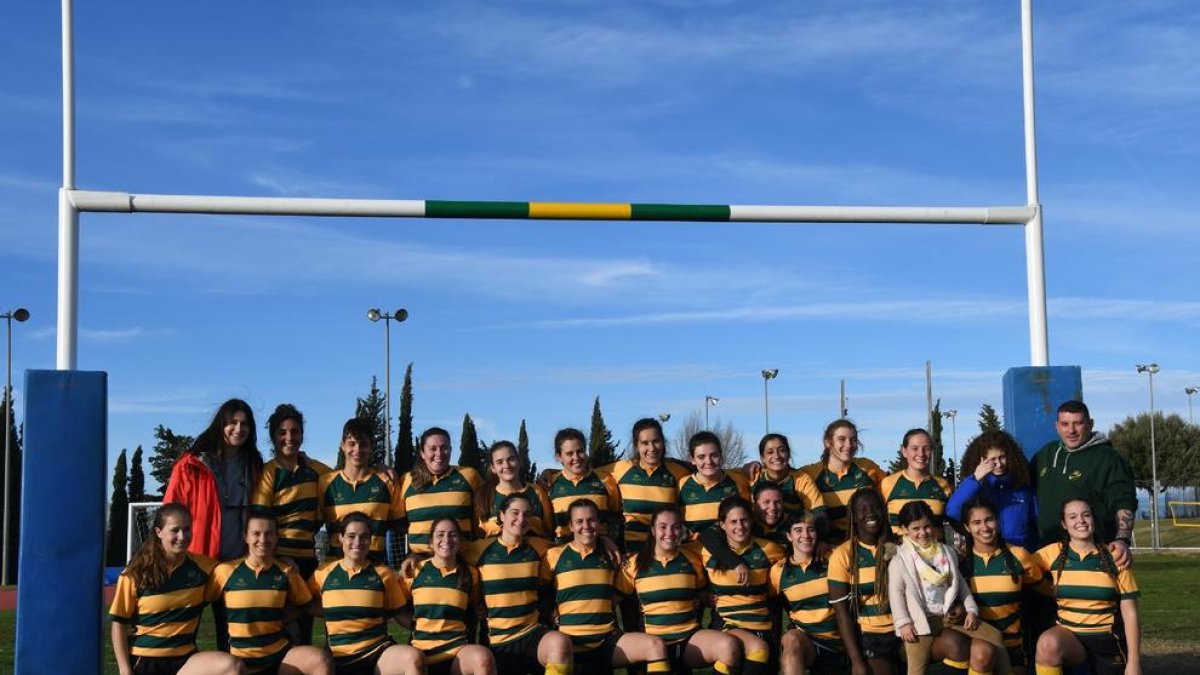 La plantilla del Inef Lleida Rugby posa con el trofeo de campeonas de Liga que les vale un ascenso.
