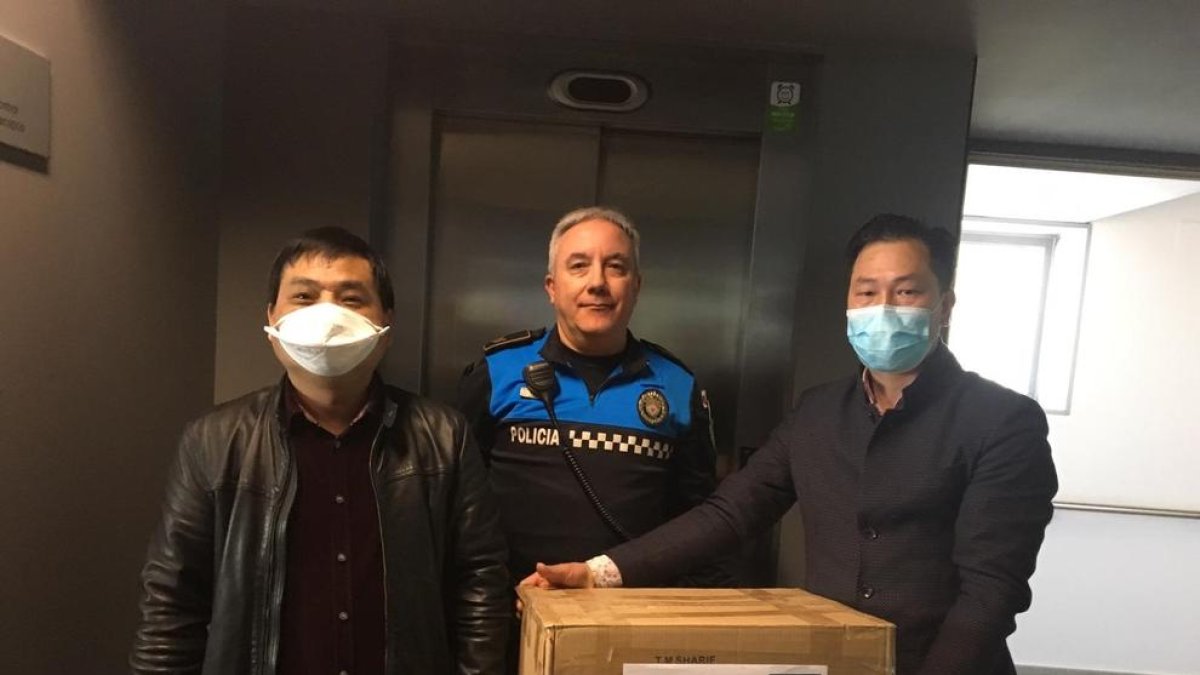 Los miembros de la entidad, entregando ayer las mascarillas.