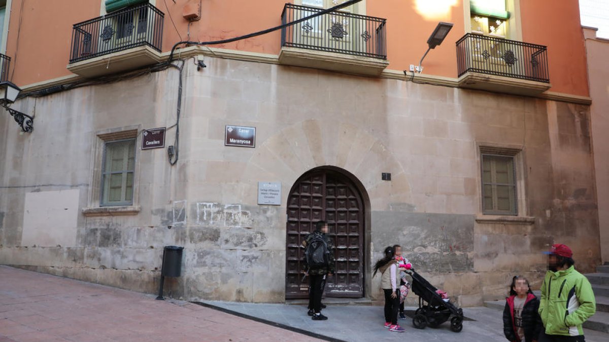 Padres y alumnos en el exterior de la sede del colegio Cervantes de la calle Cavallers.