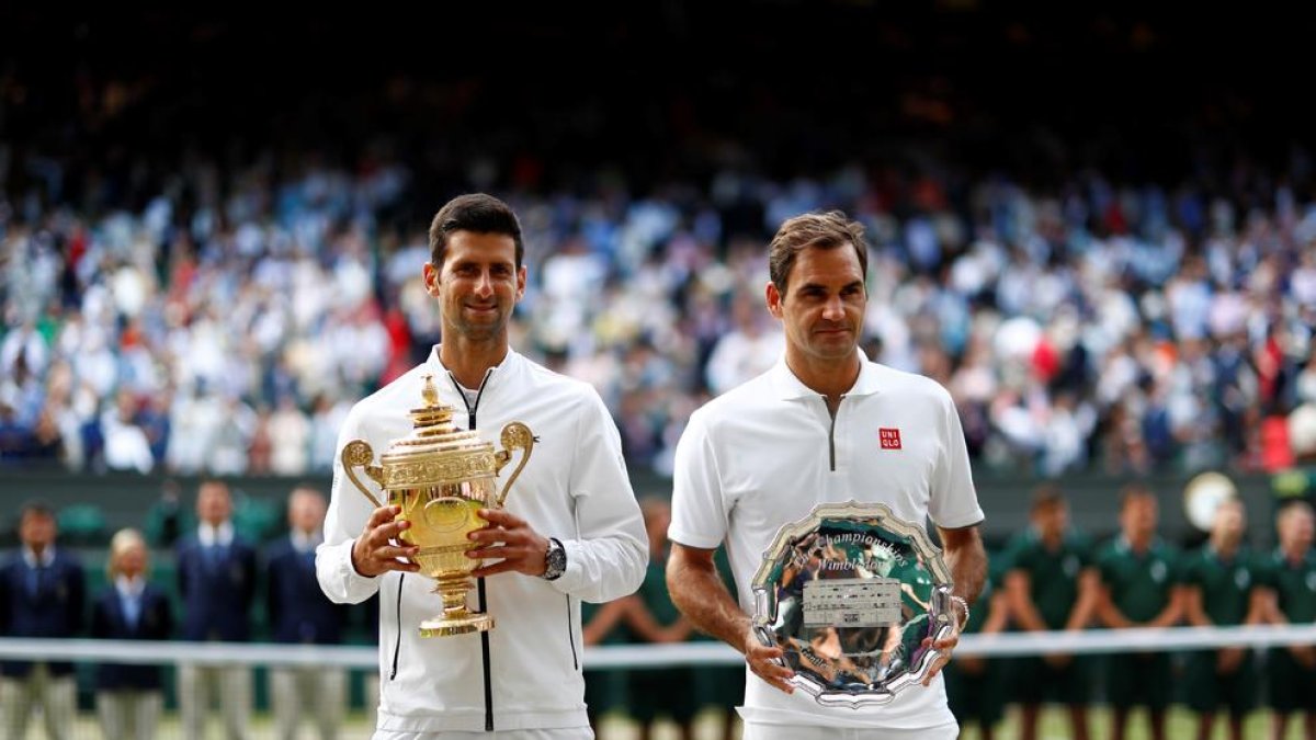 Djokovic y Federer, ayer tras la final más larga de la historia de Wimbledon que se adjudicó el serbio.