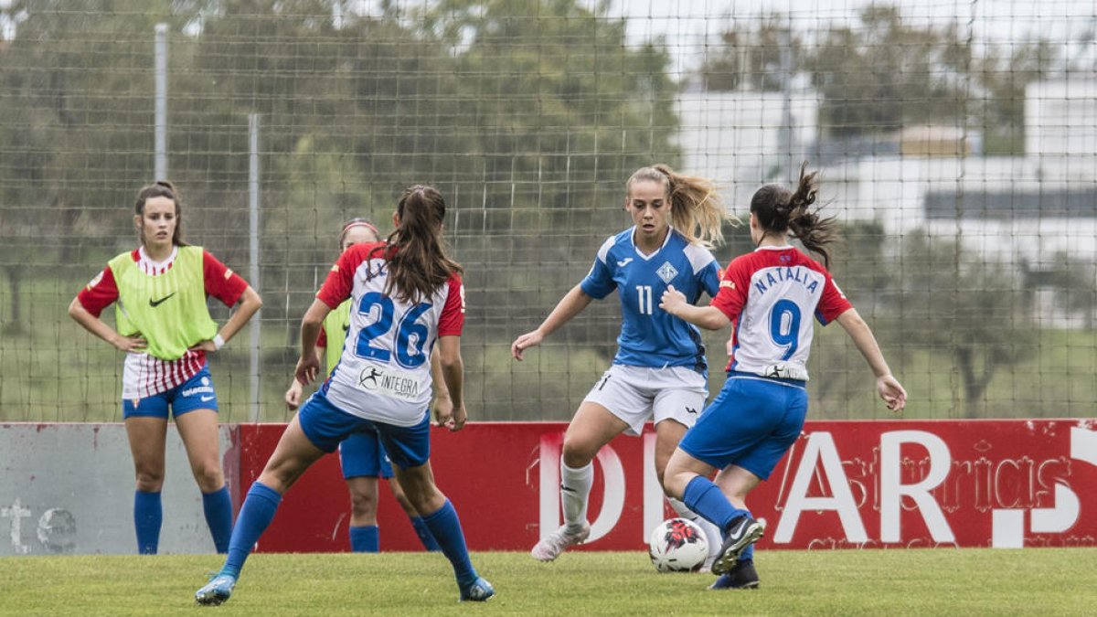 Natàlia, de blau amb el dorsal 11, intenta avançar davant de dos rivals diumenge passat a Gijón.