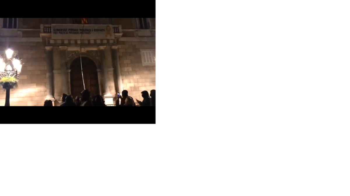 Encaputxats intenten retirar la pancarta de la Generalitat, ahir.