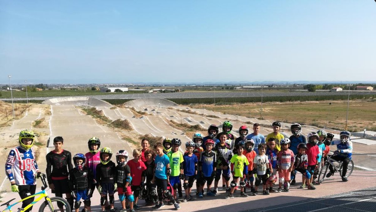 Niños de todas las edades en el circuito BMX de Vila-sana con las pistas al fondo.