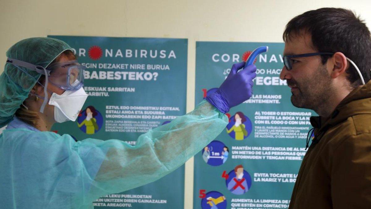 Una infermera pren la temperatura un pacient a l’entrada d’un centre de salut a Euskadi.