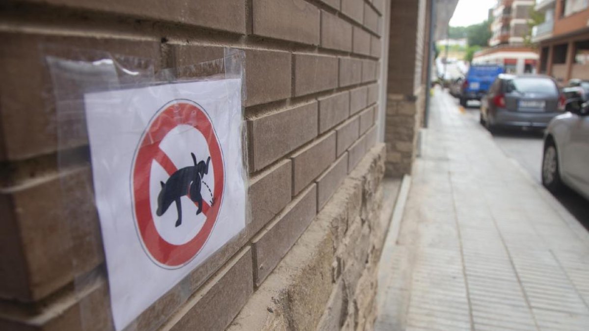 Uno de los carteles, en un fachada de la calle de Bellpuig.