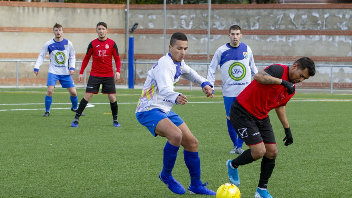 Un jugador del Tremp porta la pilota davant la pressió d’un jugador del Ponts.